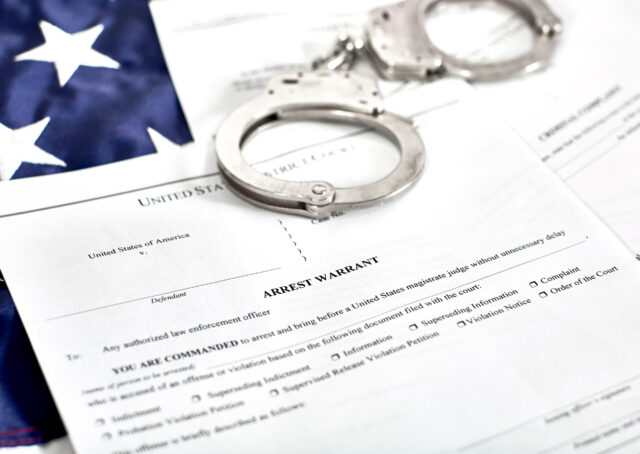 Arrest Warrant Court Papers with Handcuffs