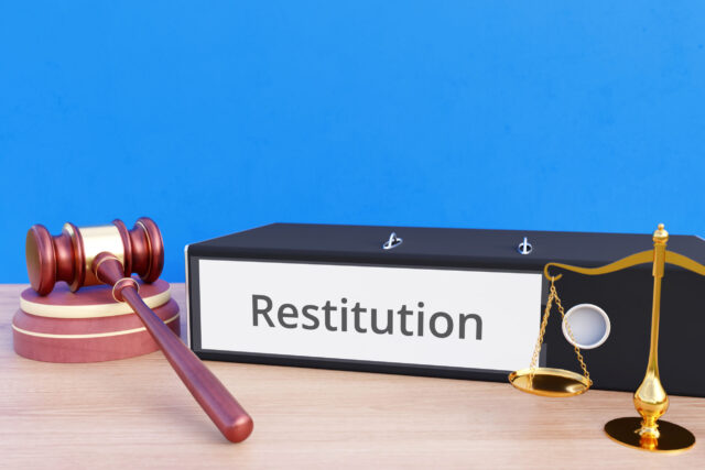 Restitution – Folder with labeling, gavel and libra – law, judgement, lawyer