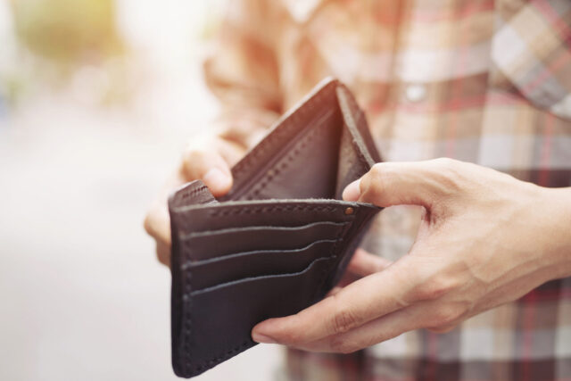 Empty wallet (no money) in the hands of an man.