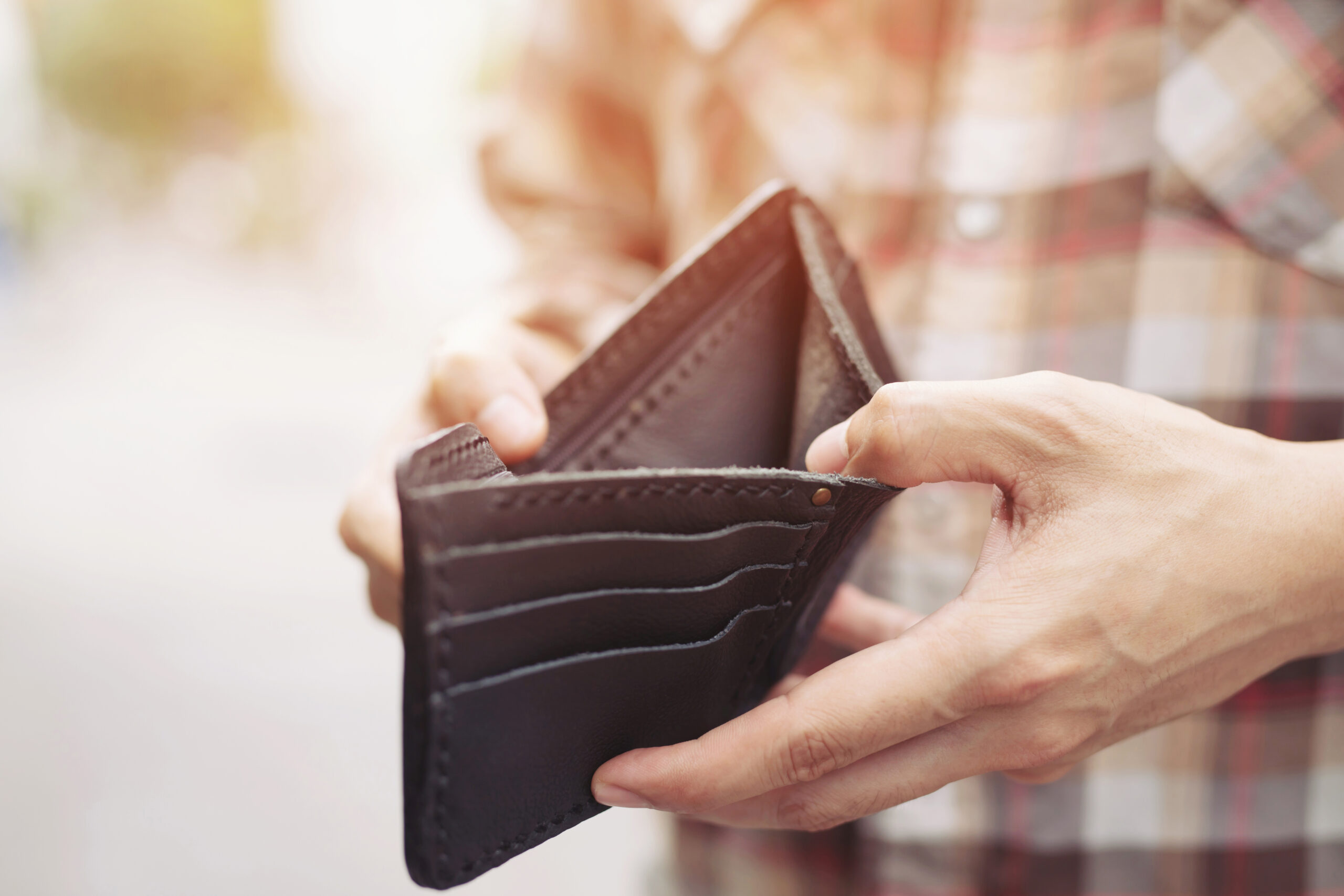 Empty wallet (no money) in the hands of an man.