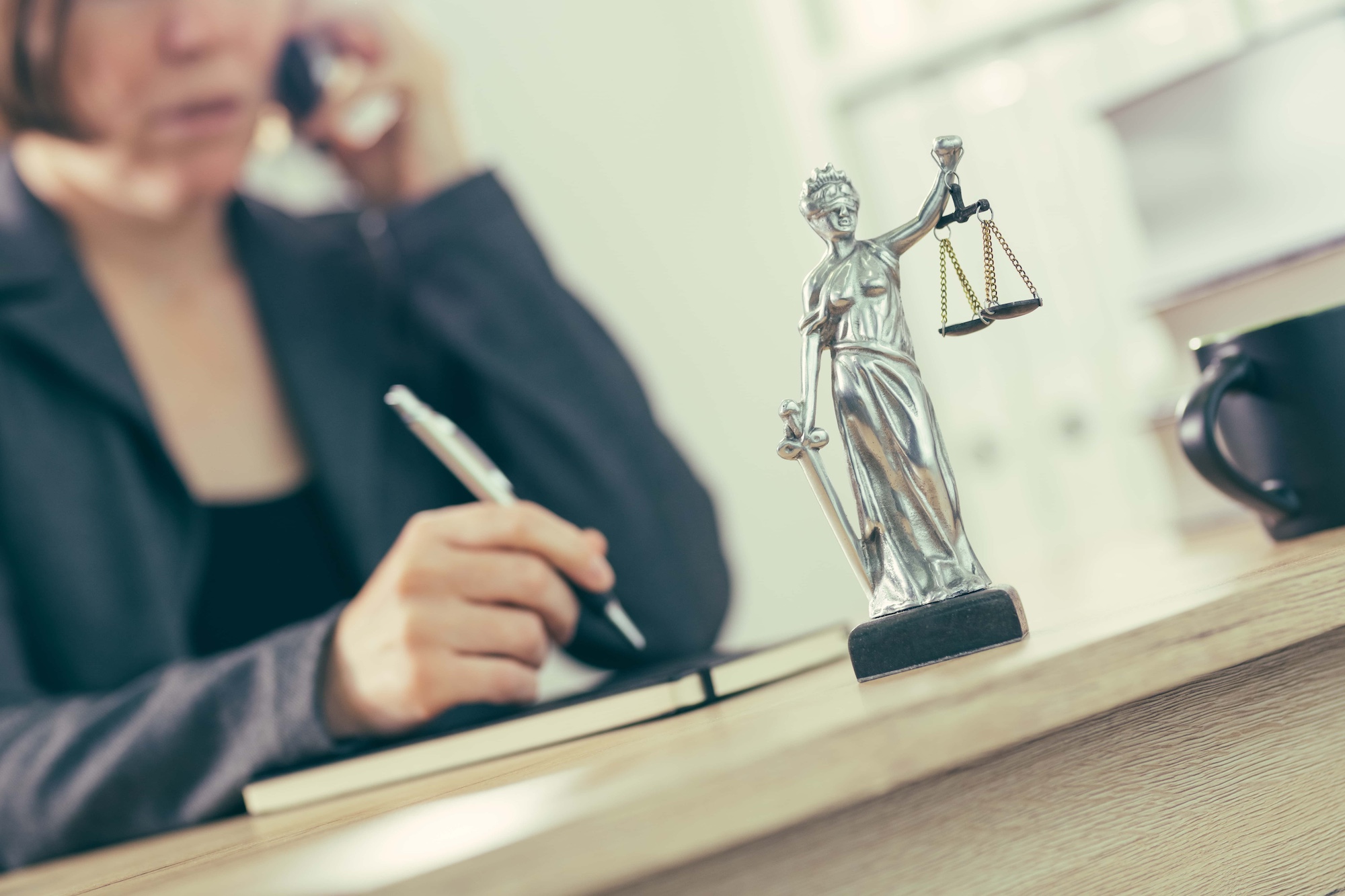 Attorney woman talking on mobile phone from her office desk