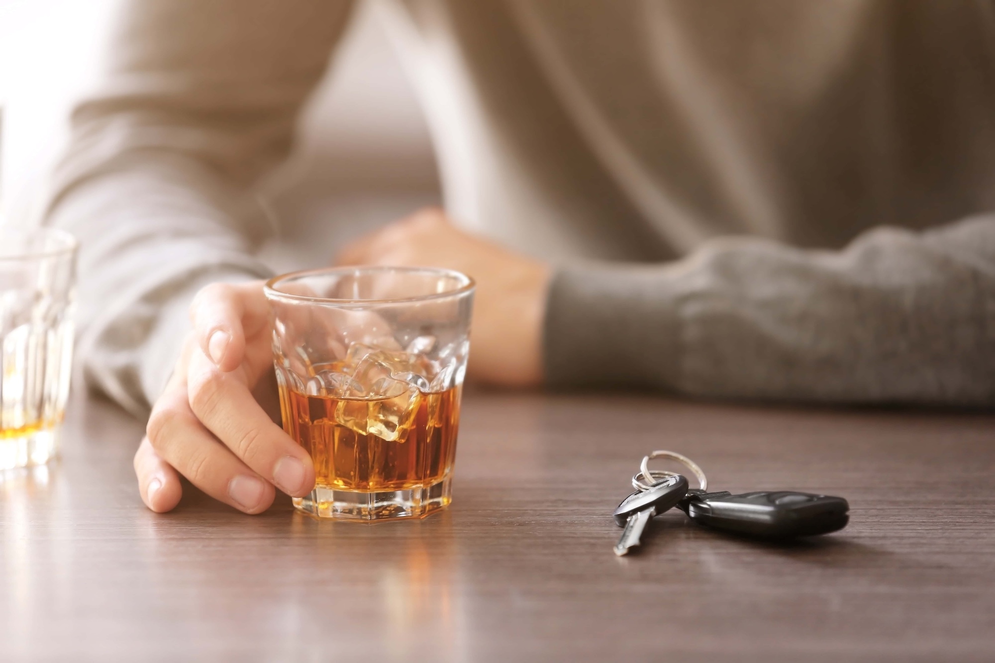 Drunk man with car key and alcoholic beverage in bar closeup. Dont drink and drive concept