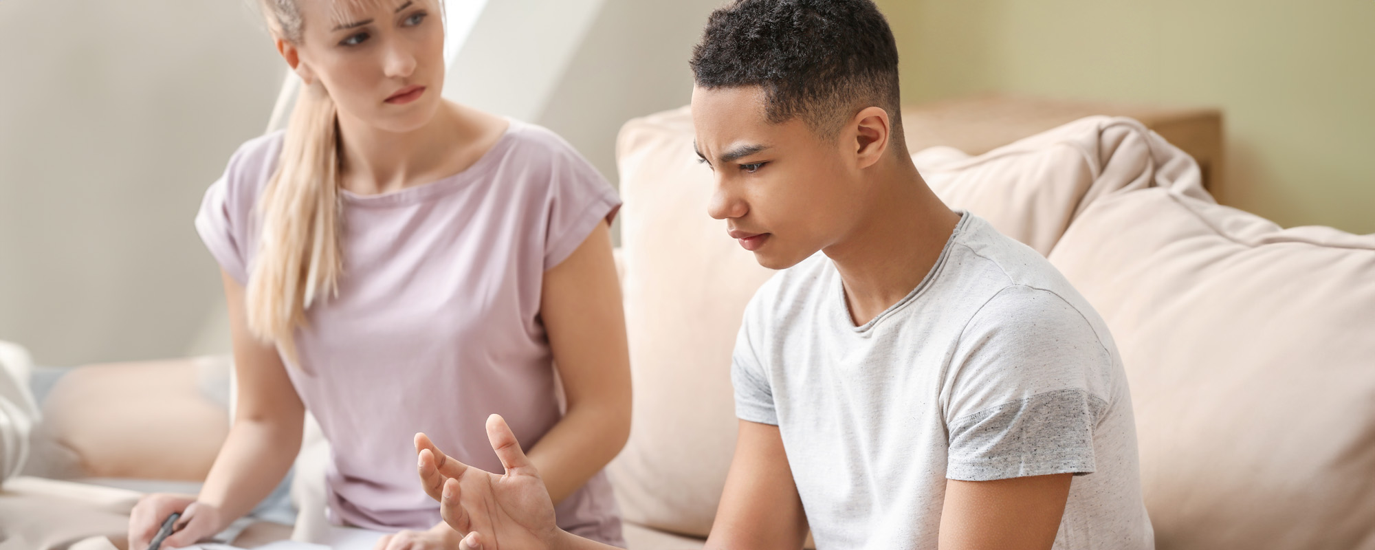 Female psychologist working with depressed teenage boy in office