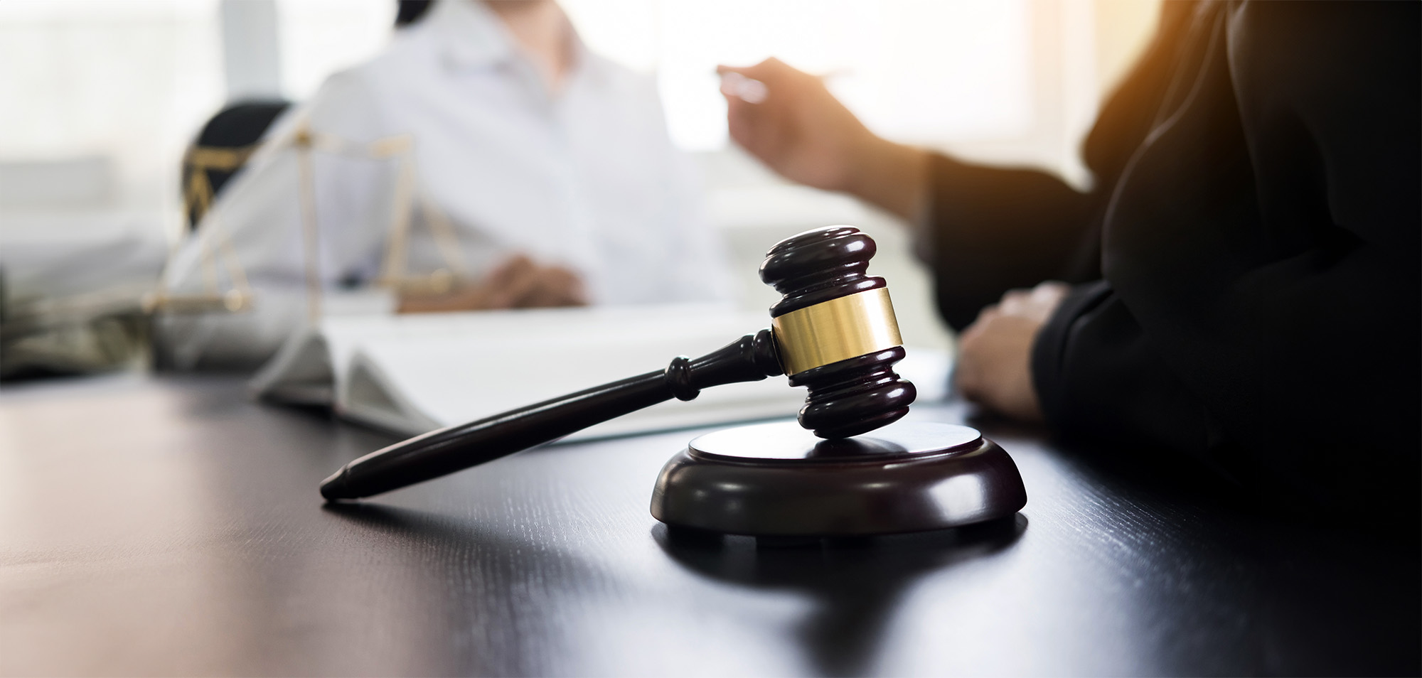 Judge gavel with lawyers advice legal at law firm in background