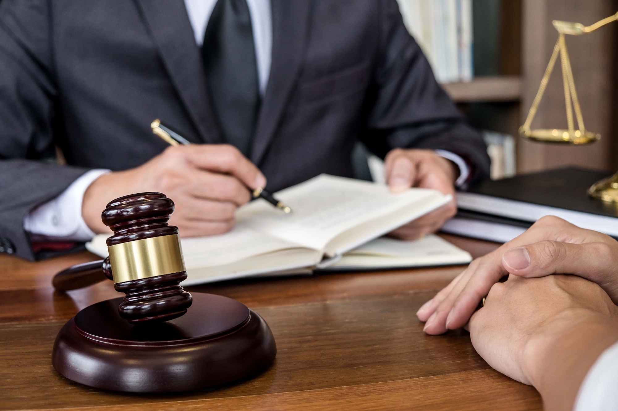 Judge gavel with scales of justice Businesswoman and male lawyers or counselor discussing contract papers at law firm in office. Concepts of law