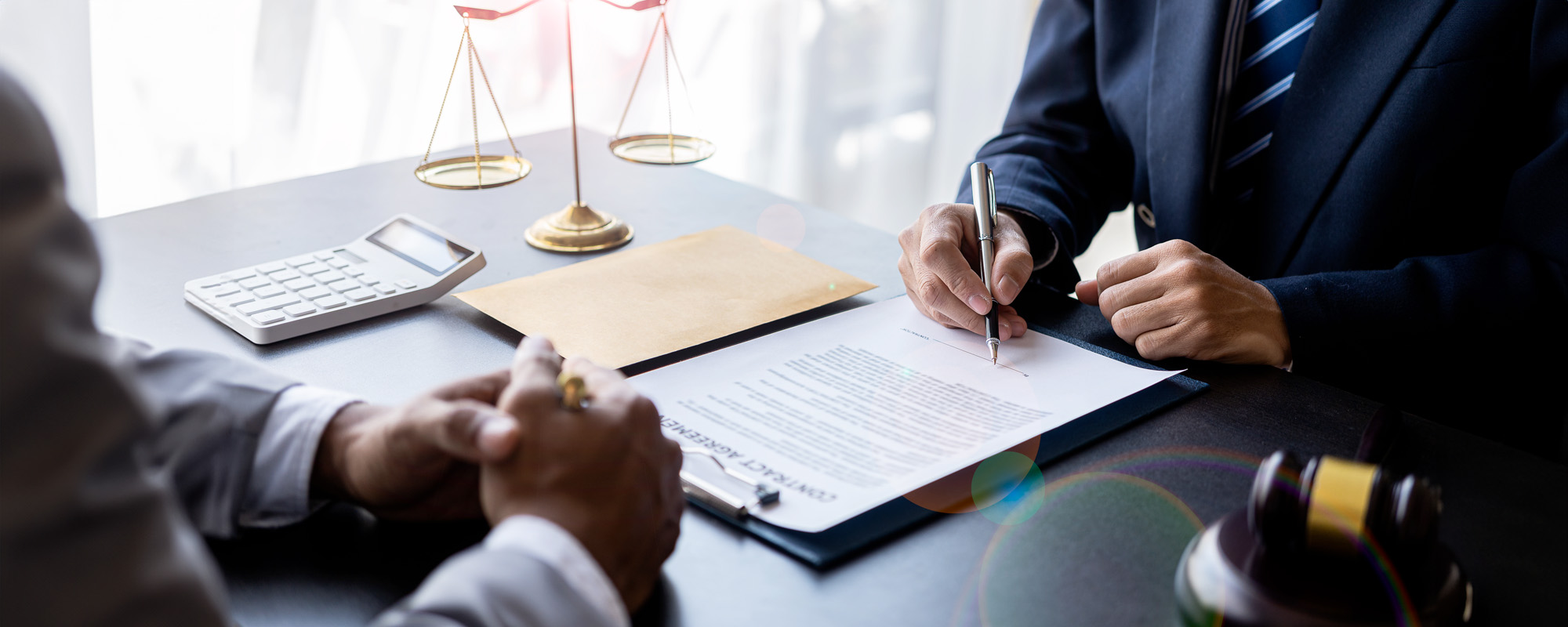 Lawyer working with client discussing contract documents with brass scales on law in courtroom Consulting to help clients win court cases