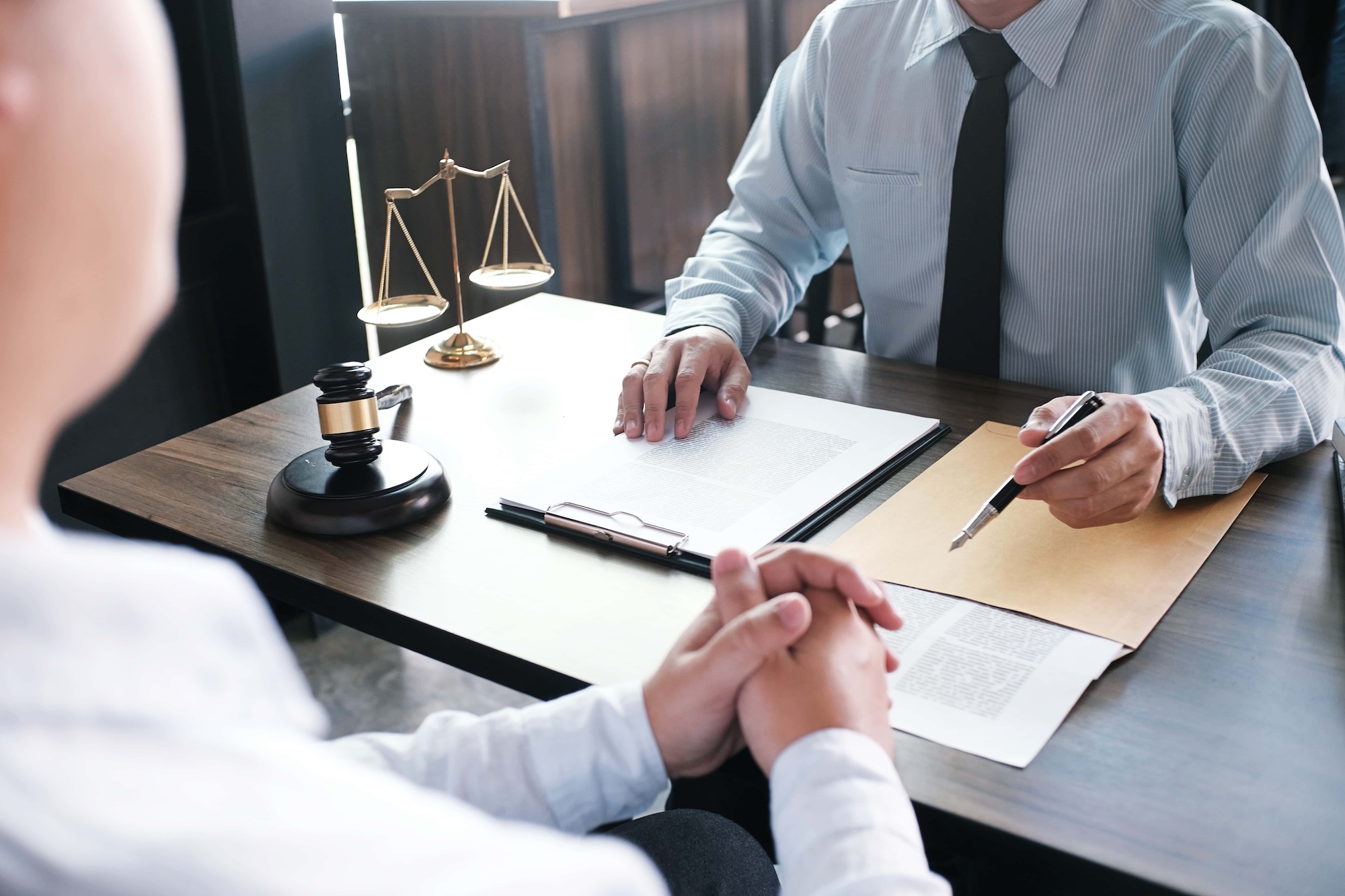 Legal counsel presents to the client a signed contract with gavel and legal law
