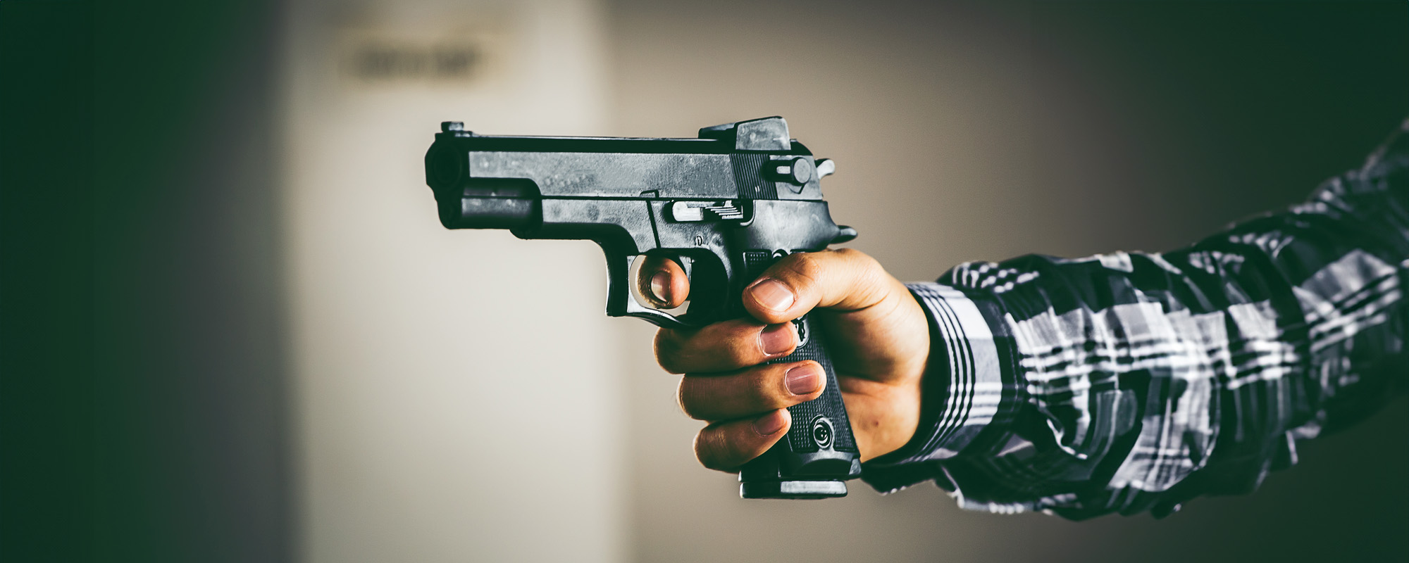 Robber holding a gun. Low key photo and selective focus. criminality concept