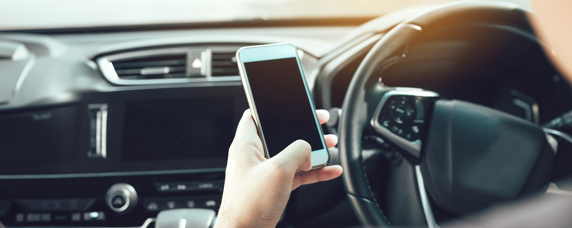 The man hand is using the phone while driving