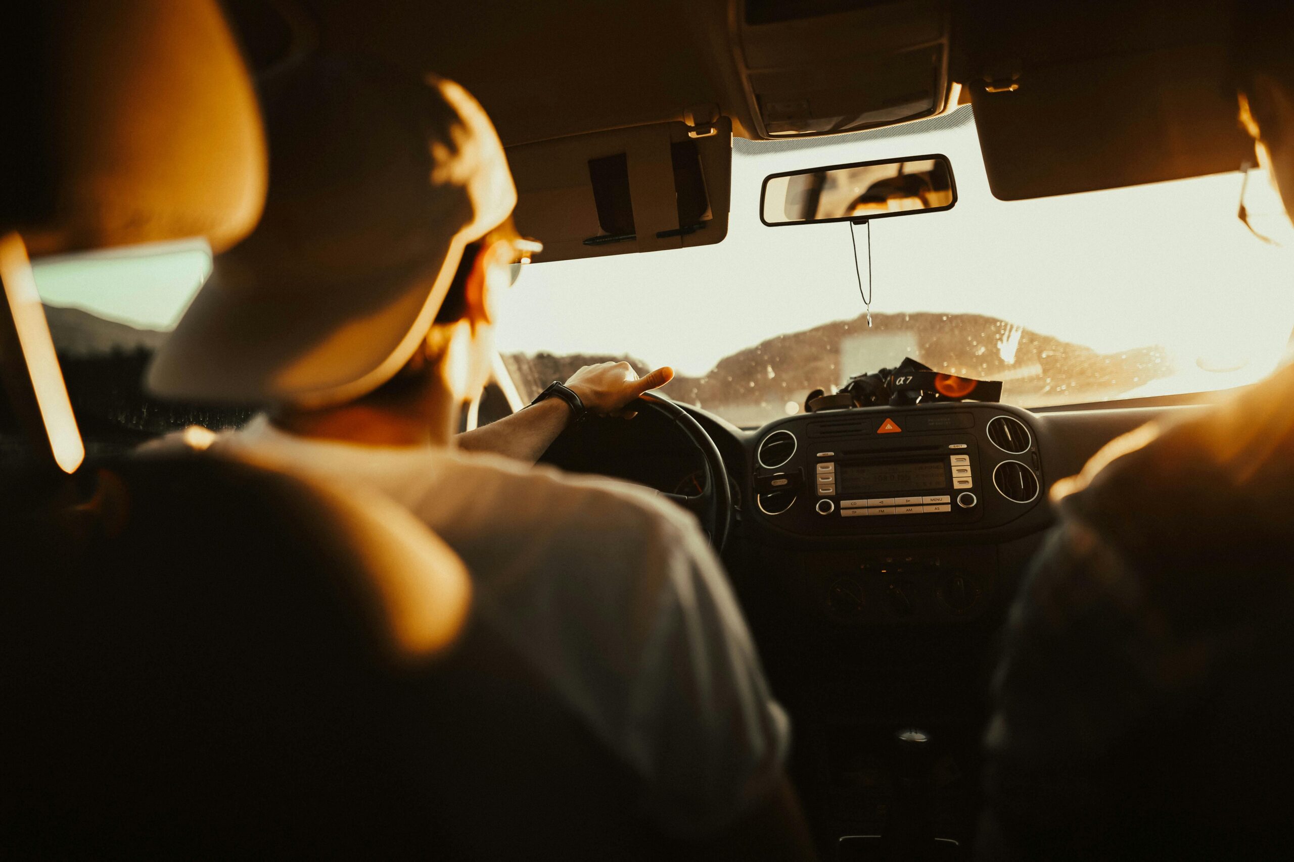 A male college student driving recklessly on busy road at sunset; Rockland County Reckless Driving Attorney concept image
