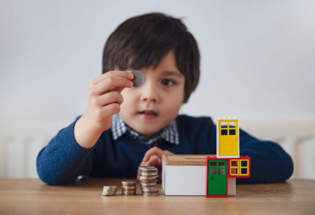 Blurry face of preschool kid showing 10 pence with smiling face,